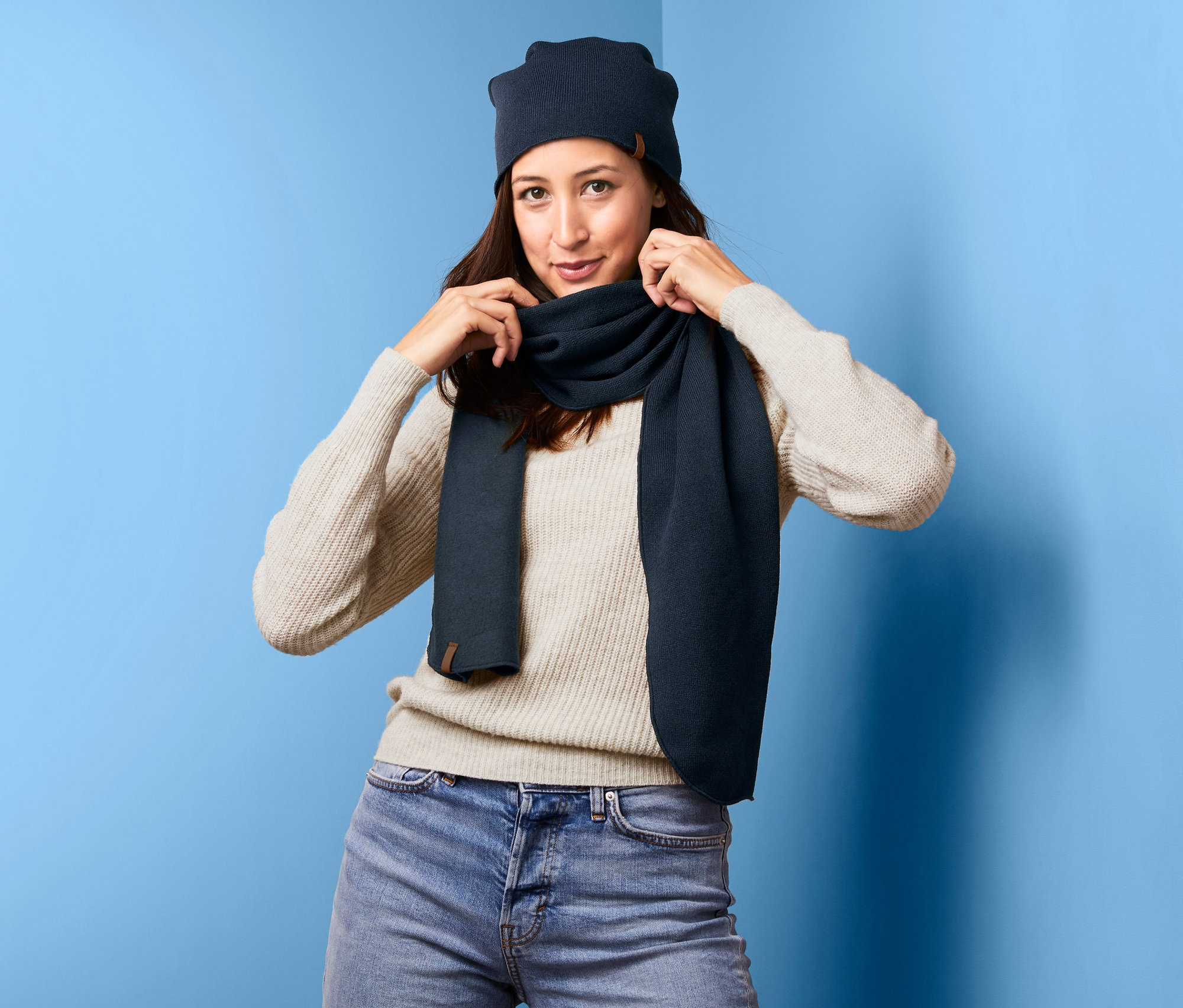 Kadın örgü polar atkısını düzeltiyor.