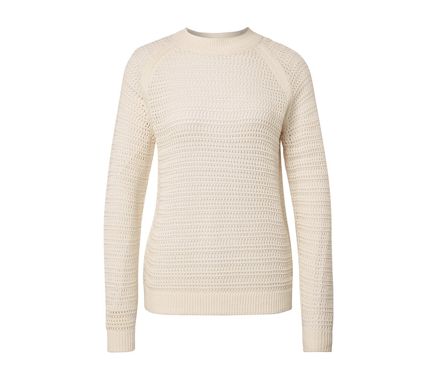 Beyaz bir arka plan üzerinde krem rengi, pointelle örgü kazak.