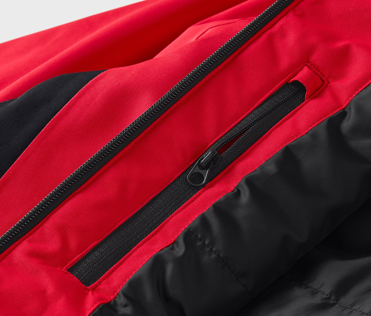 Fermuarlı kırmızı ve siyah bir ceketin yakın çekimi.