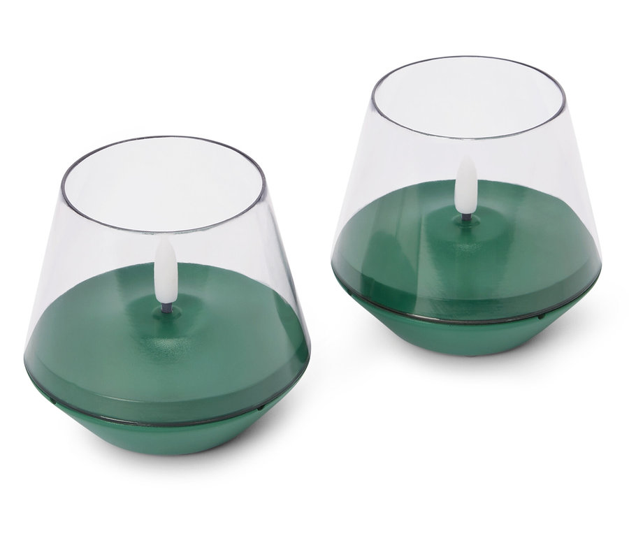 Beyaz bir arka planda iki adet yeşil, elektrikli tealight mum.