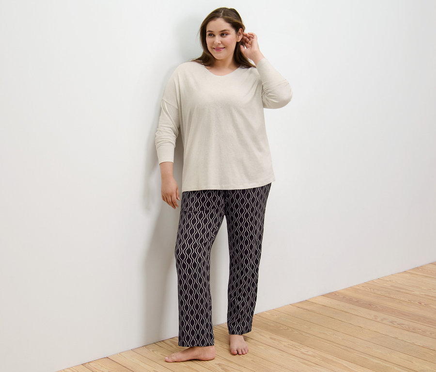 Pijamalı bir kadın duvara yaslanmış duruyor