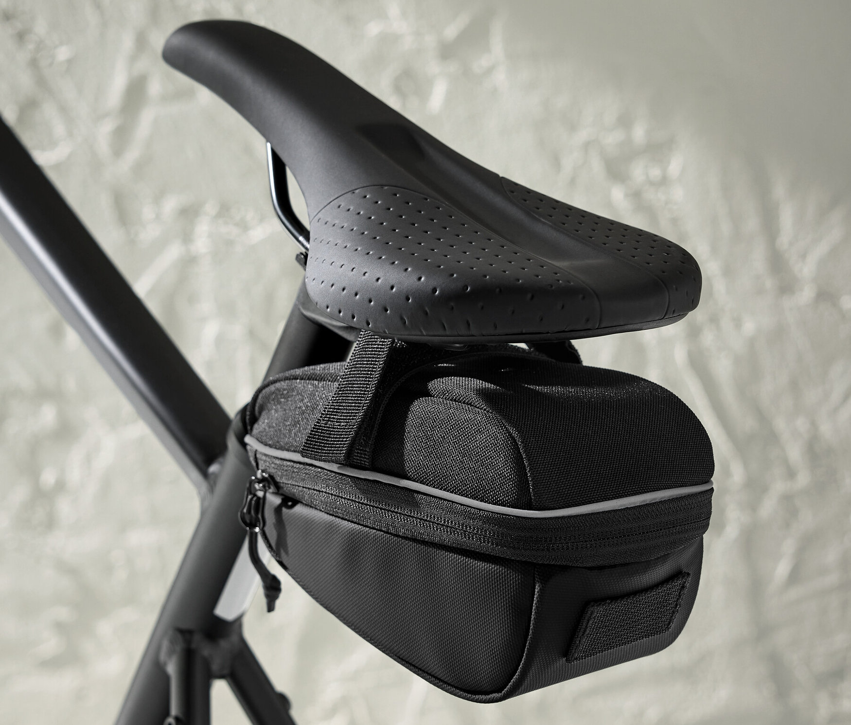 Bisiklet selesinin altına takılmış siyah bir bisiklet sele çantası.