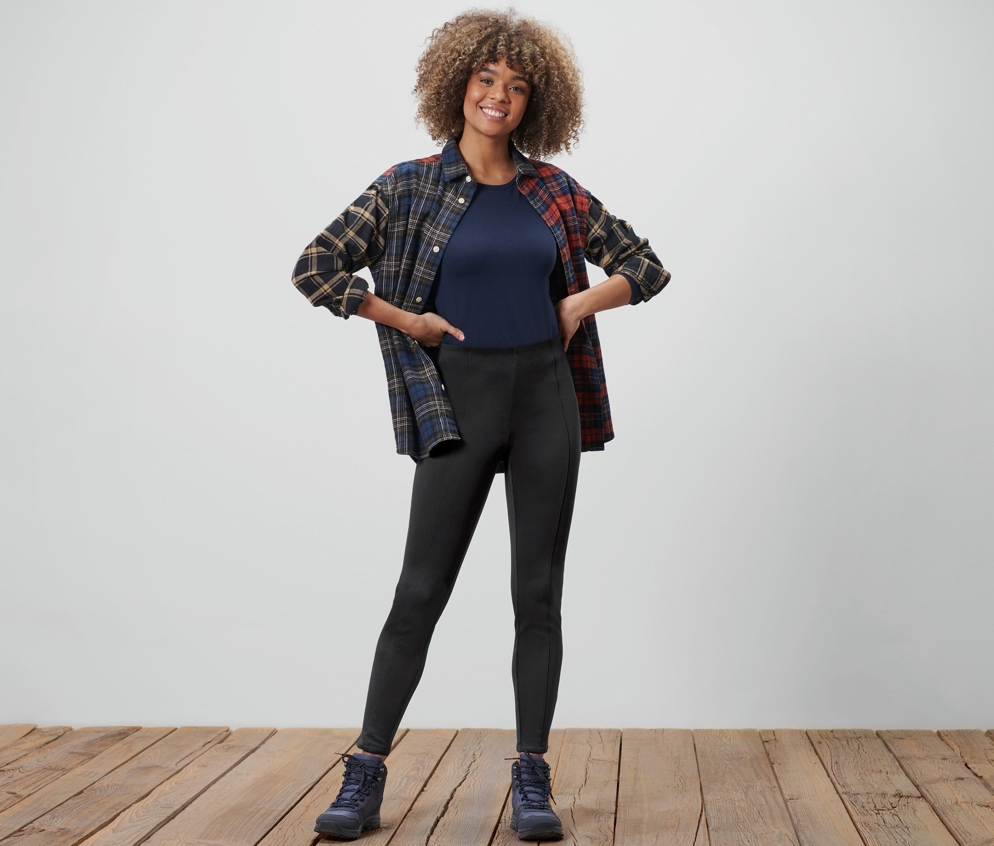 Kadın termal tayt, tişört ve pazen gömleğiyle poz veriyor.