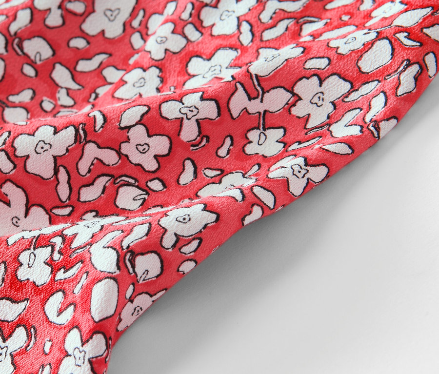 Baskılı, kırmızı midi eteğin yakın çekimi.