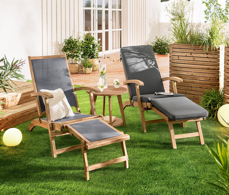 Çimde yan yana duran, Uzatılabilir Ayak Destekli Şezlong »Lenja«. Aralarında 2 Kademeli Yan Sehpa »Lenja« bulunmaktadır. Arka planda Güneş Enerjili Küre Lamba, Kum Görünümlü, yakl. 20 cm ve Güneş Enerjili Küre Lamba, Kum Görünümlü, yakl. 30 cm görülmektedir.