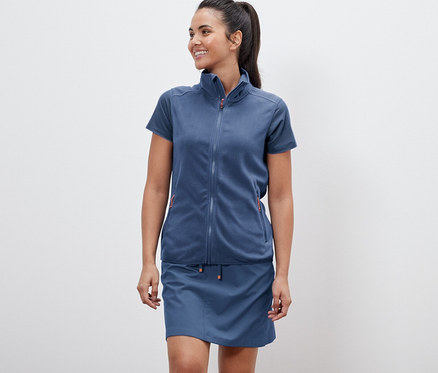 Kadın bir polar yelek ve etek giyiyor.