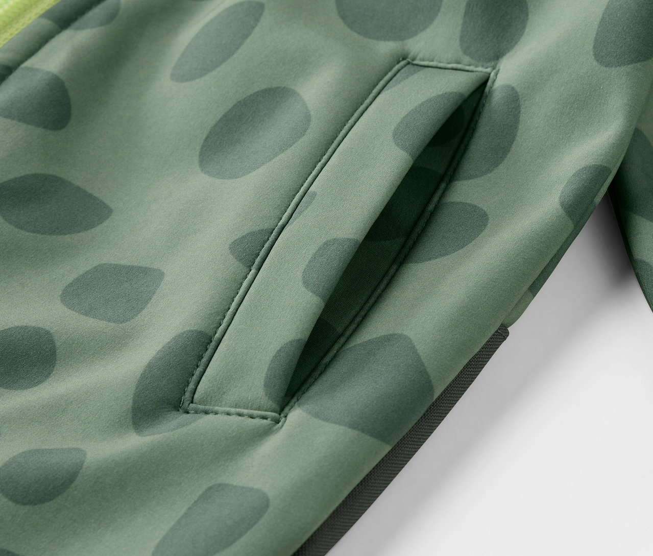 Desenli ve cepli çocuk softshell tulumunun yakın çekim detayı.