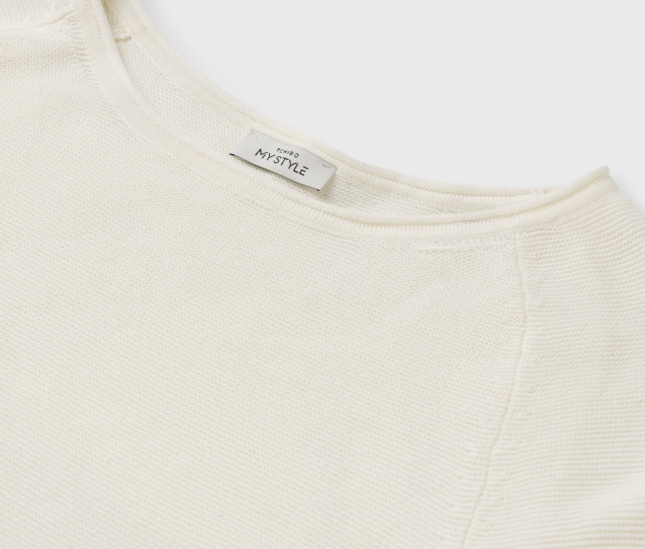 MY STYLE etiketli krem rengi bir kazağın detayı.