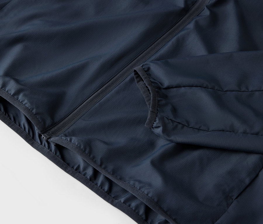 Lacivert fermuarlı ve cepli bir ceketin yakın çekimi.