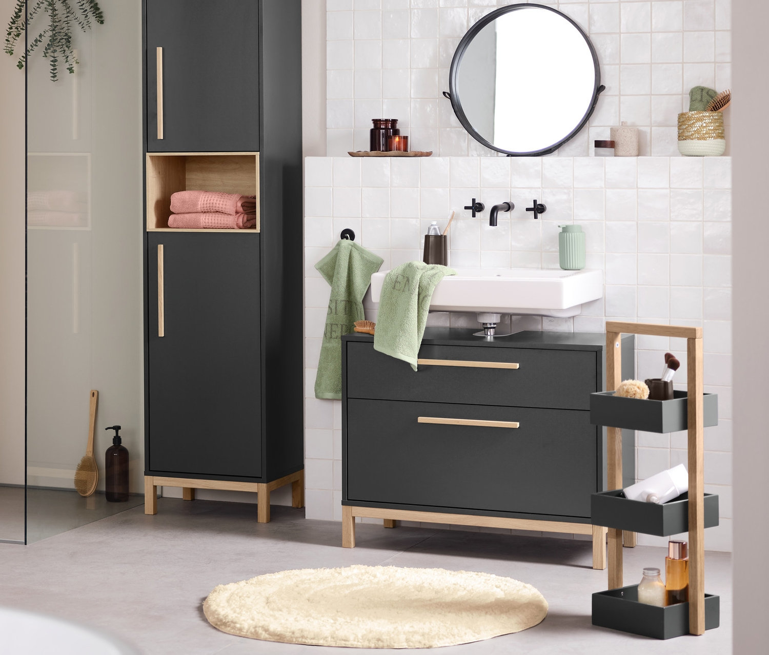 Banyo iç mekanı; lavabo, ayna ve antrasit renkli Eklund banyo dolapları. Ön planda bir küvet bulunuyor.