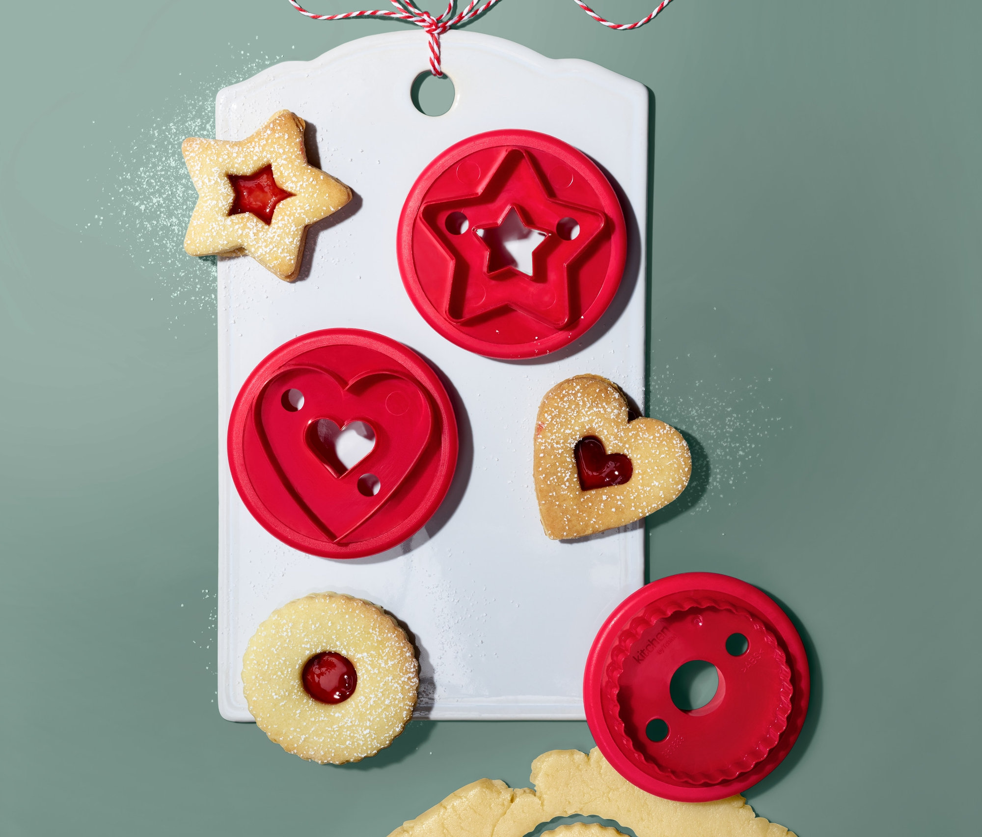 Beyaz tahtada yıldız, kalp ve daire şekillerinde 3 Linzer Kurabiye Kalıbı. Marmelatlı ve hamurlu kesilmiş şekiller.