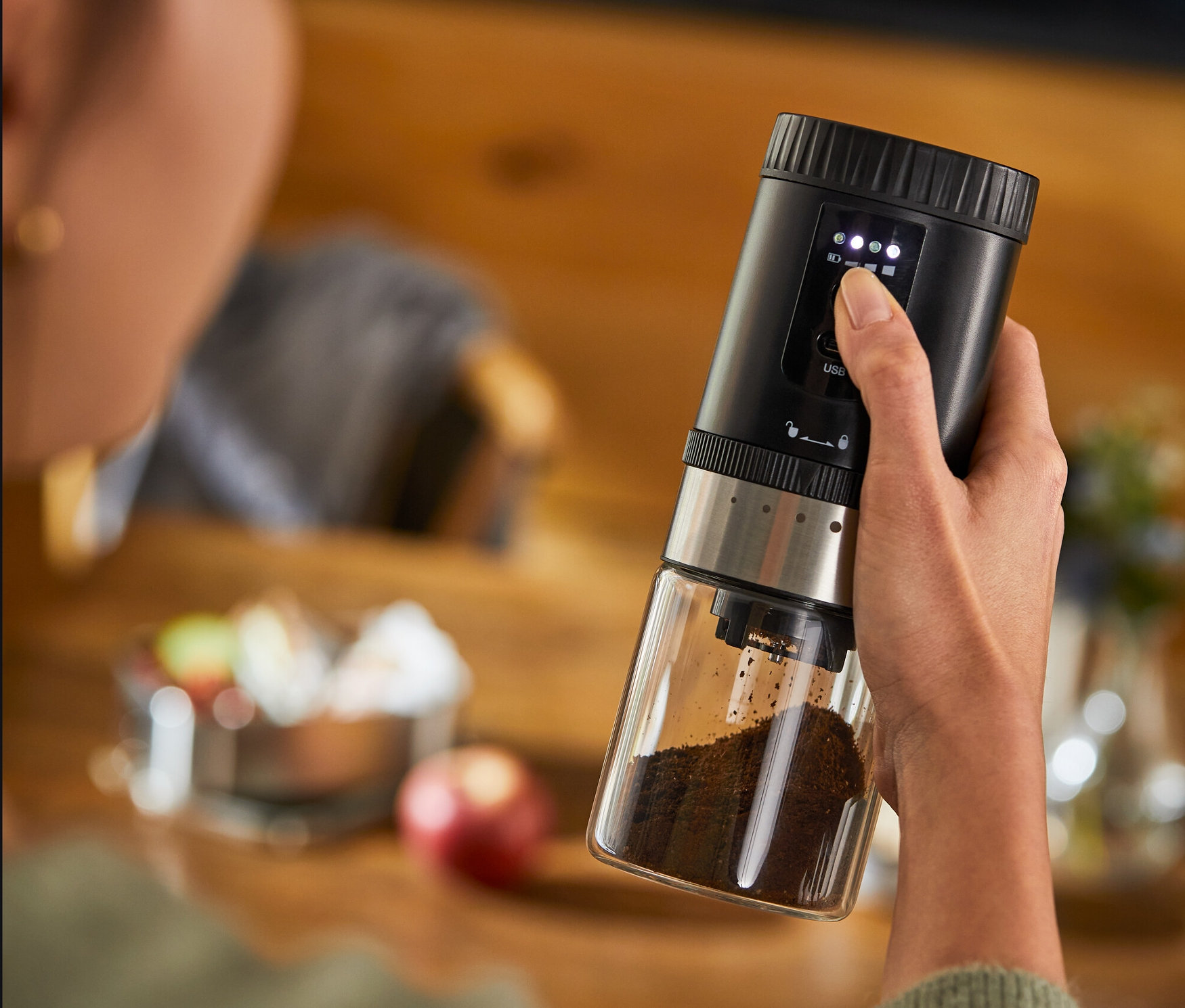 Kadın şarjlı kahve değirmeni tutuyor.