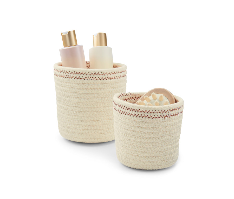 İçinde iki şişe bulunan, kırık beyaz-bakır rengi 2 adet saklama sepeti. 