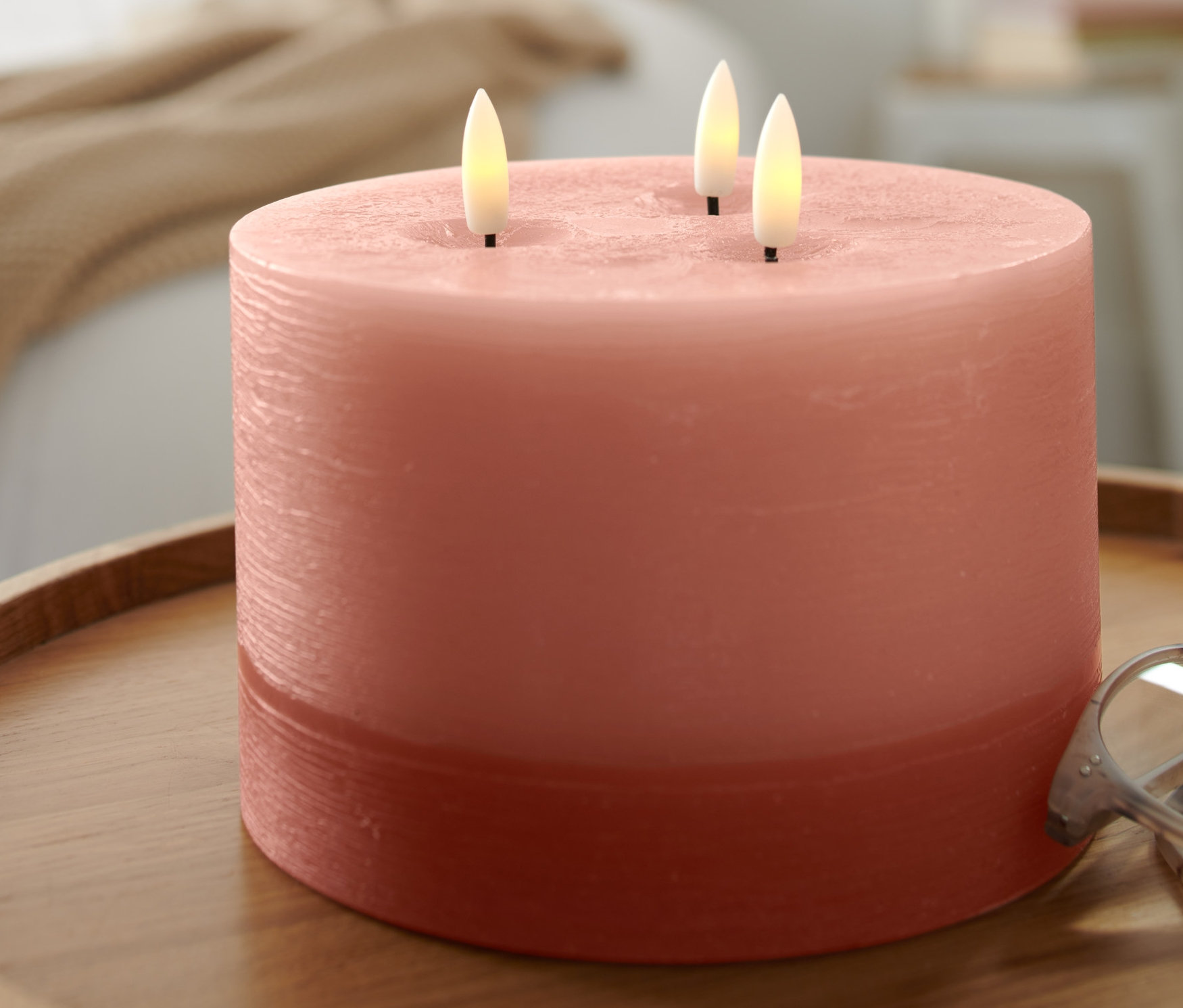 Ahşap bir masanın üzerinde XL Led Mum duruyor.