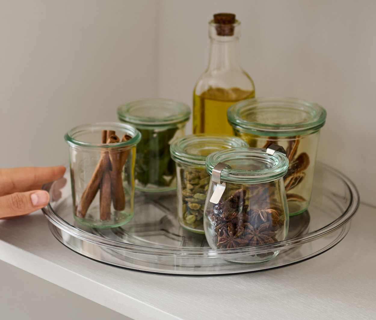 Bir el rafta baharatlarla dolu döner tablaya uzanıyor.