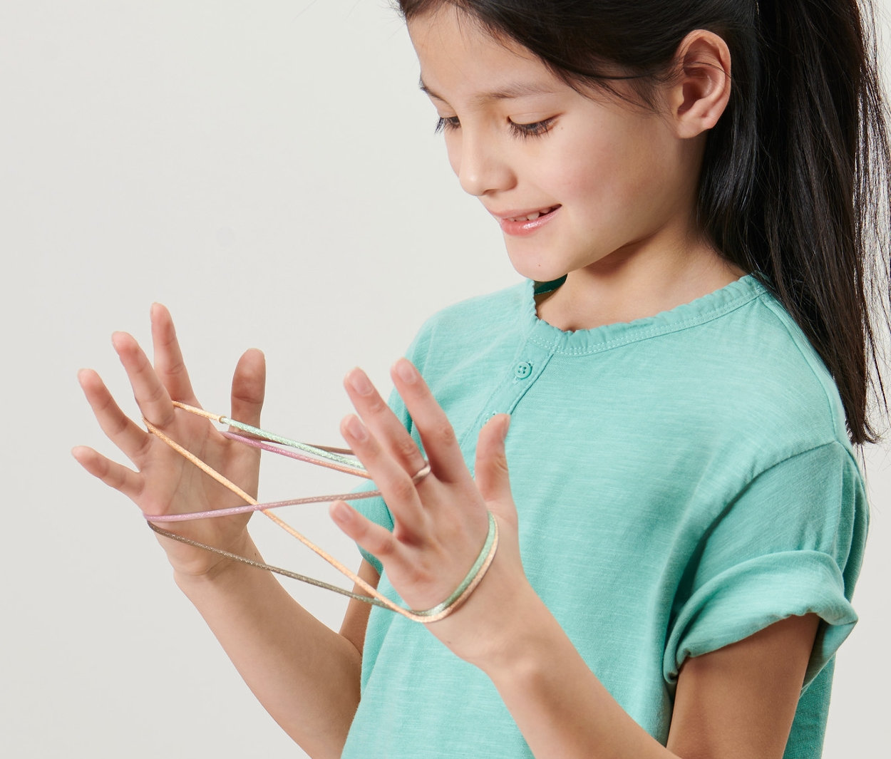 Kız, ellerinde ip ile Parmak Twist, 2'li Set oynuyor.