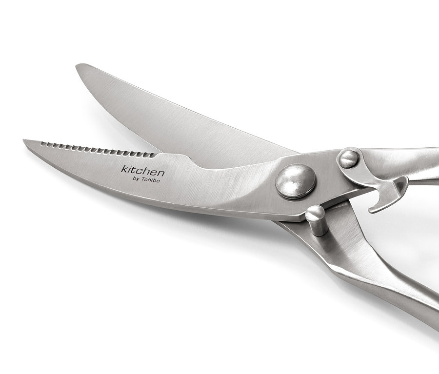 Beyaz bir arka plan üzerinde açık paslanmaz çelik kümes hayvanı makasının yakın çekimi.