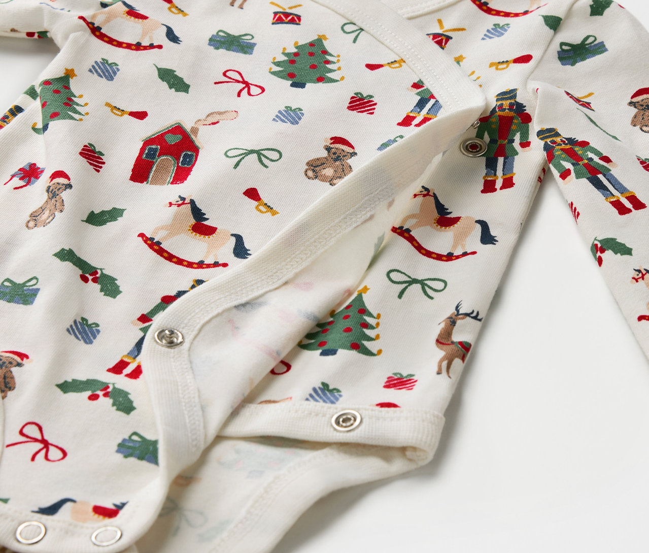 Noel desenli, çıtçıtlı pamuklu bebek zıbını detayı.