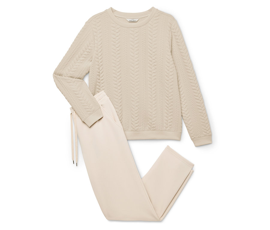 Krem rengi, örgü desenli bir sweatshirt ve ipli pantolondan oluşan ev giyim.