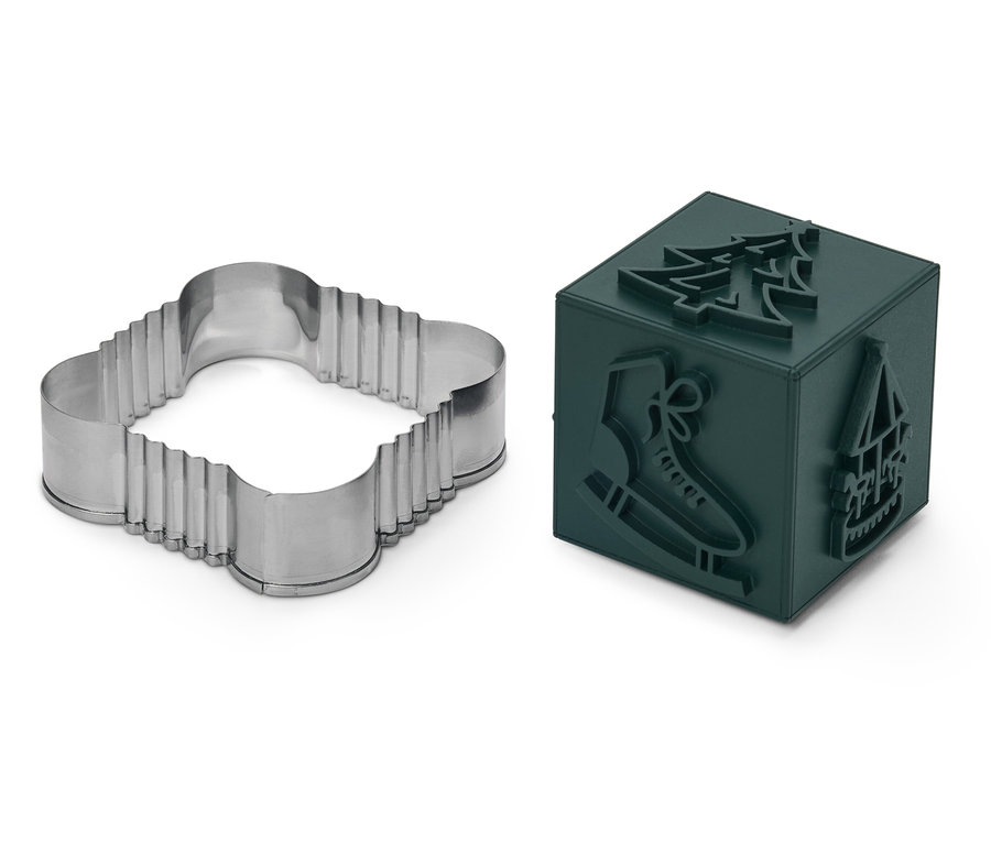 Dört yapraklı yonca şeklinde kurabiye kalıbı ve oyulmuş Noel motifli yeşil küp.