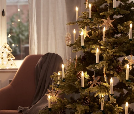Bir Noel ağacı 30 LED Noel ağacı mumları ve süslemelerle süslenmiştir.