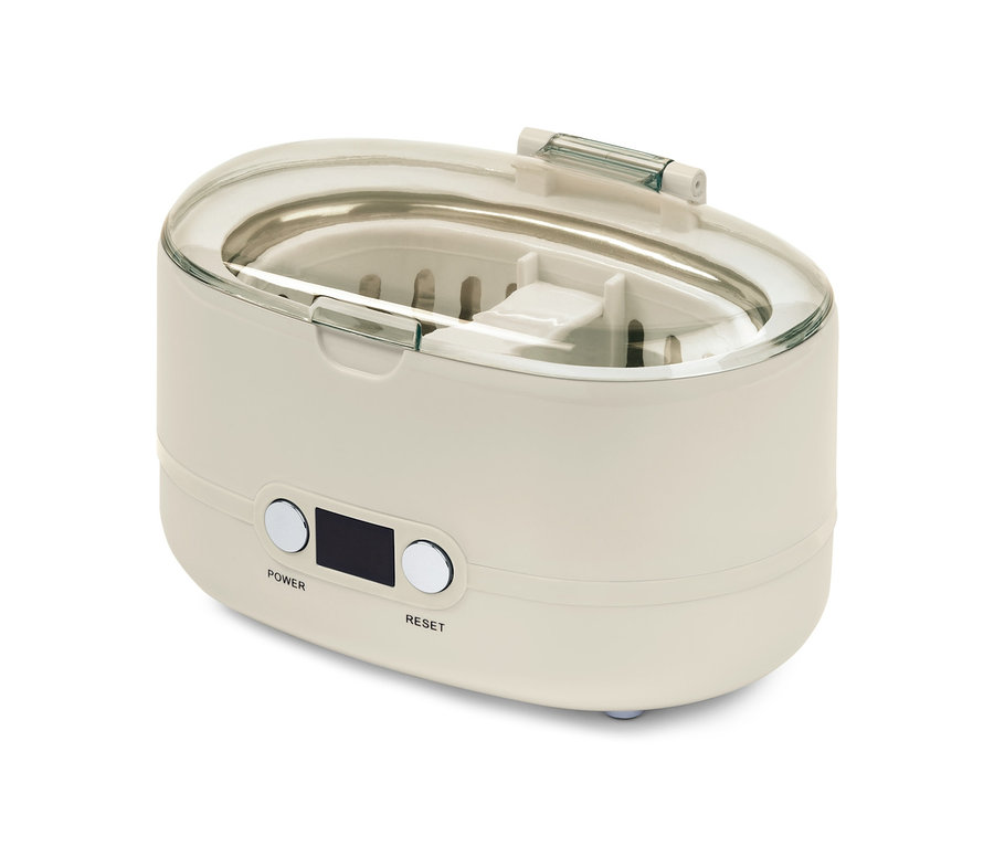 Beyaz bir arka plan üzerinde şeffaf kapaklı bir ultrasonik temizleyici.