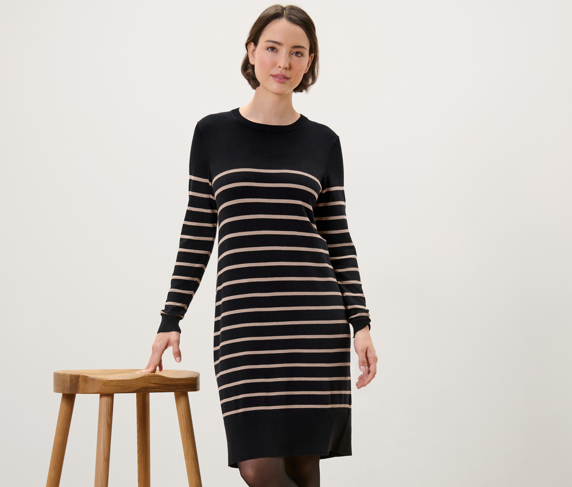 Kadın, Çizgili İnce Örgü Elbise içinde poz veriyor.