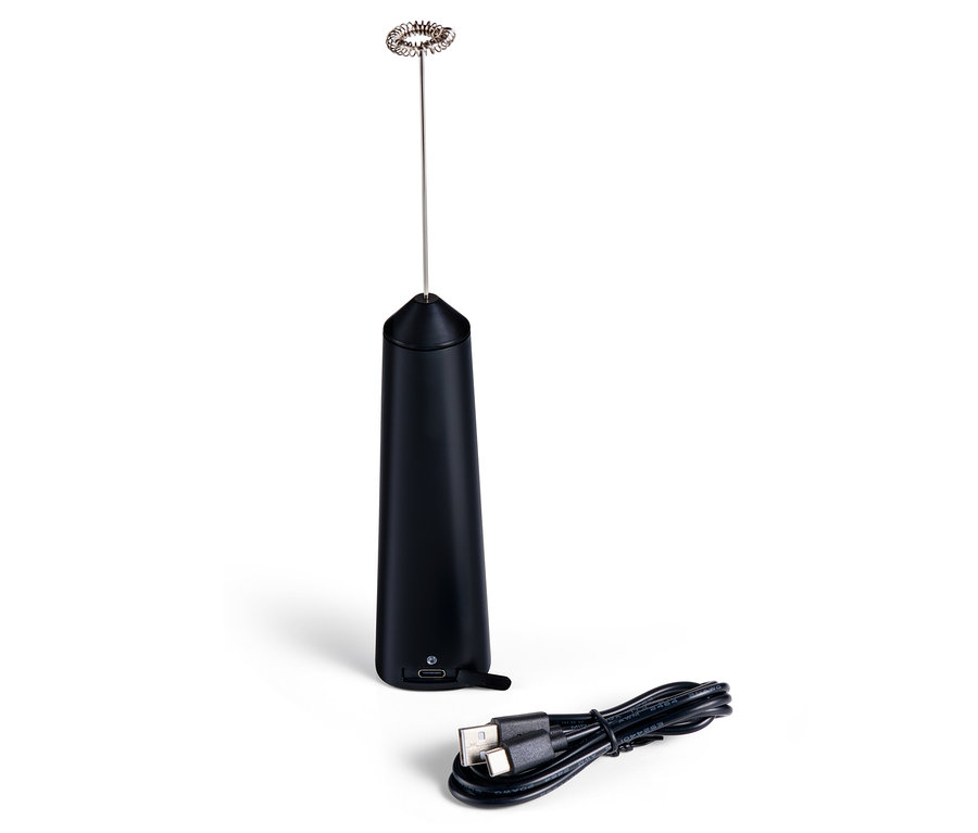 Siyah şarjlı süt köpürtücü ve şarj kablosu beyaz bir yüzey üzerinde duruyor.