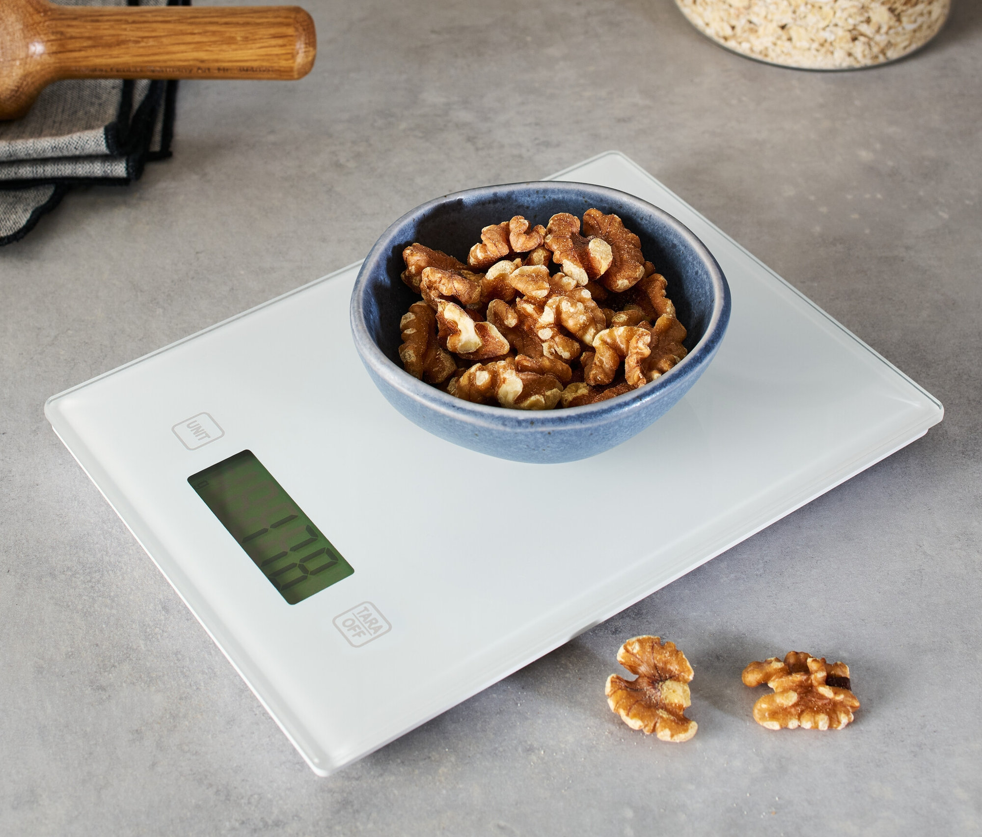 Dijital mutfak tartısında bir kase ceviz.