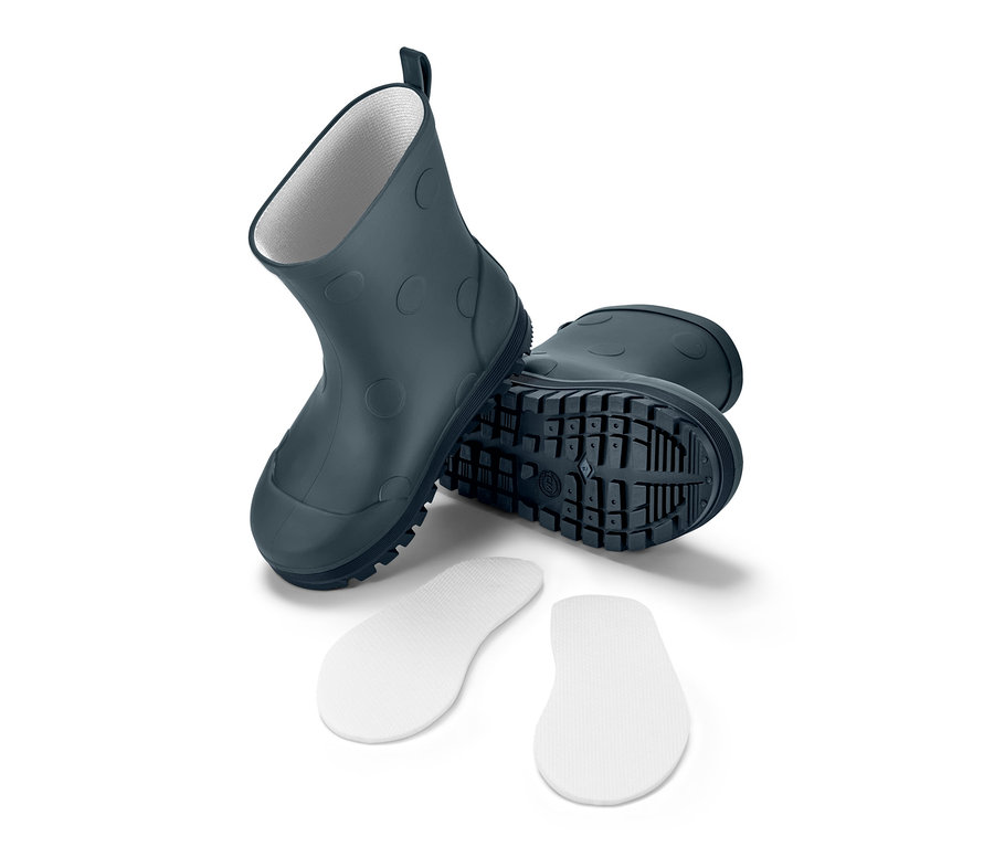 Küçük Çocuk Yağmur Çizmesi ve beyaz bir arka plan üzerinde iki adet beyaz ayakkabı tabanlığı.