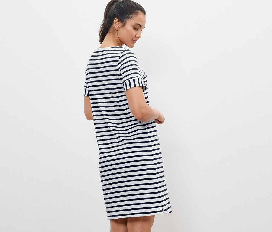 Kadın çizgili jarse elbise içinde poz veriyor.