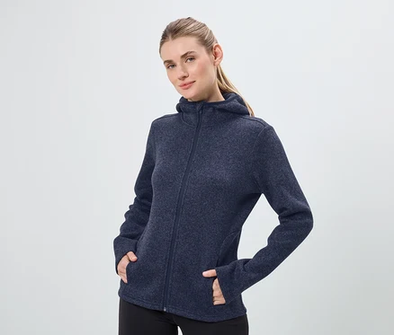 Kadın lacivert, fermuarlı kapüşonlu bir sweatshirt ve siyah pantolon giyiyor.