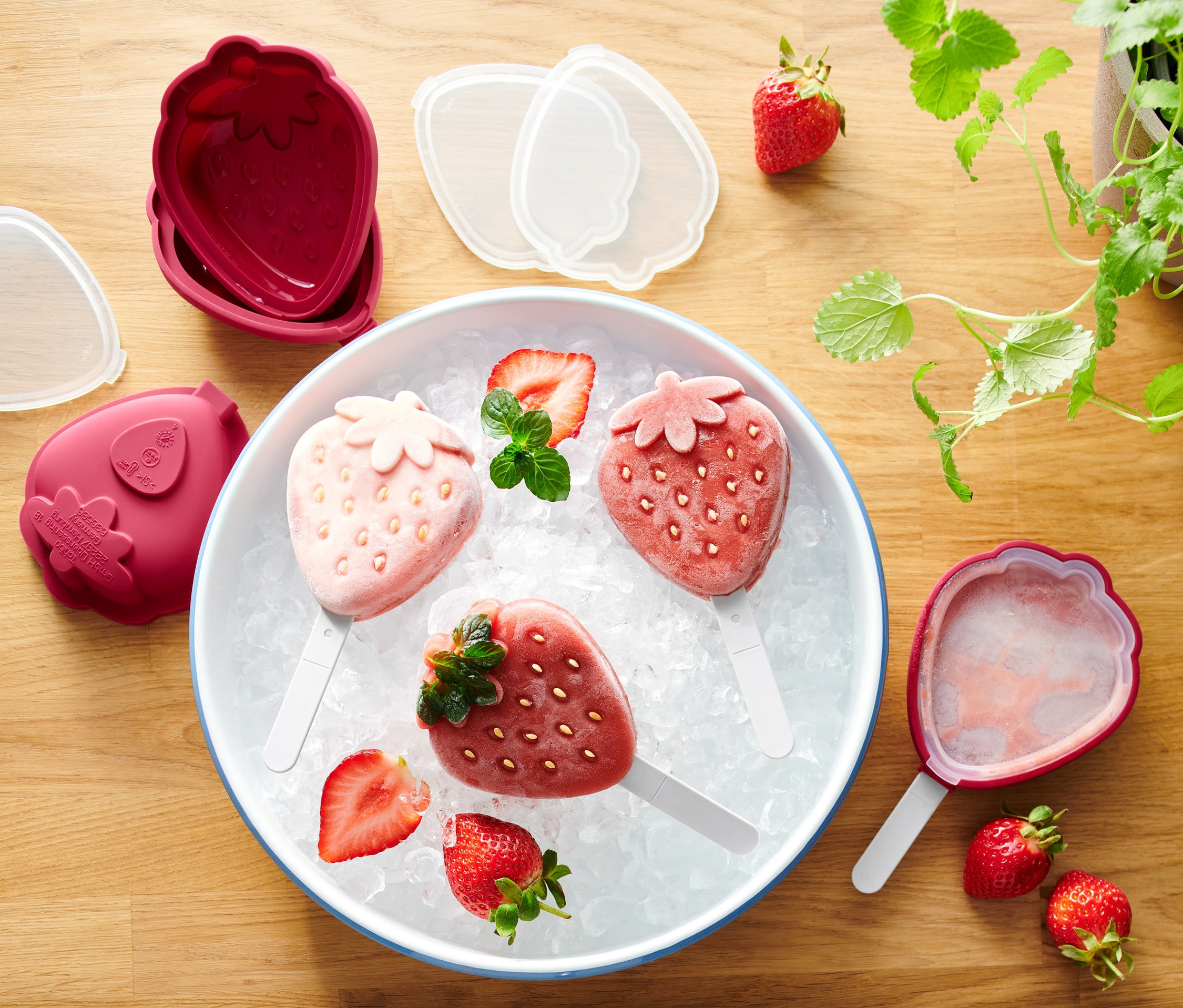 Bir kasede buz üzerinde üç adet çilekli dondurma, yanında 4 Adet Dondurma Kalıbı.