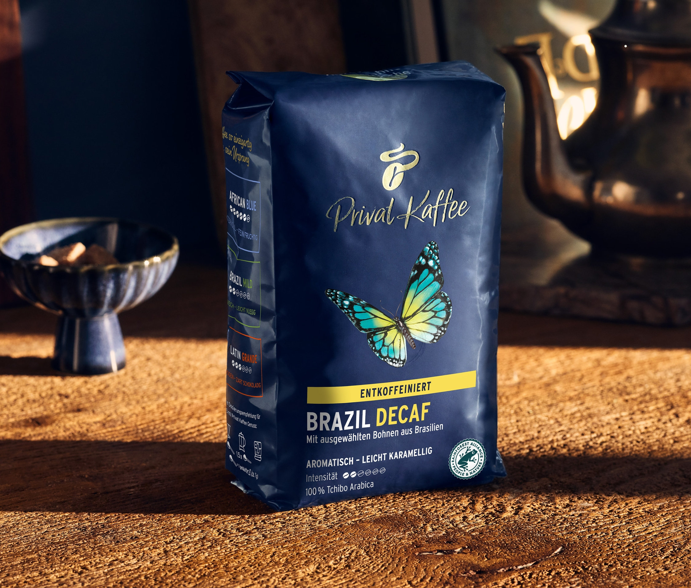 Bir paket Privat Kaffee Brazil Decaf kahvesi ahşap bir masanın üzerinde duruyor.