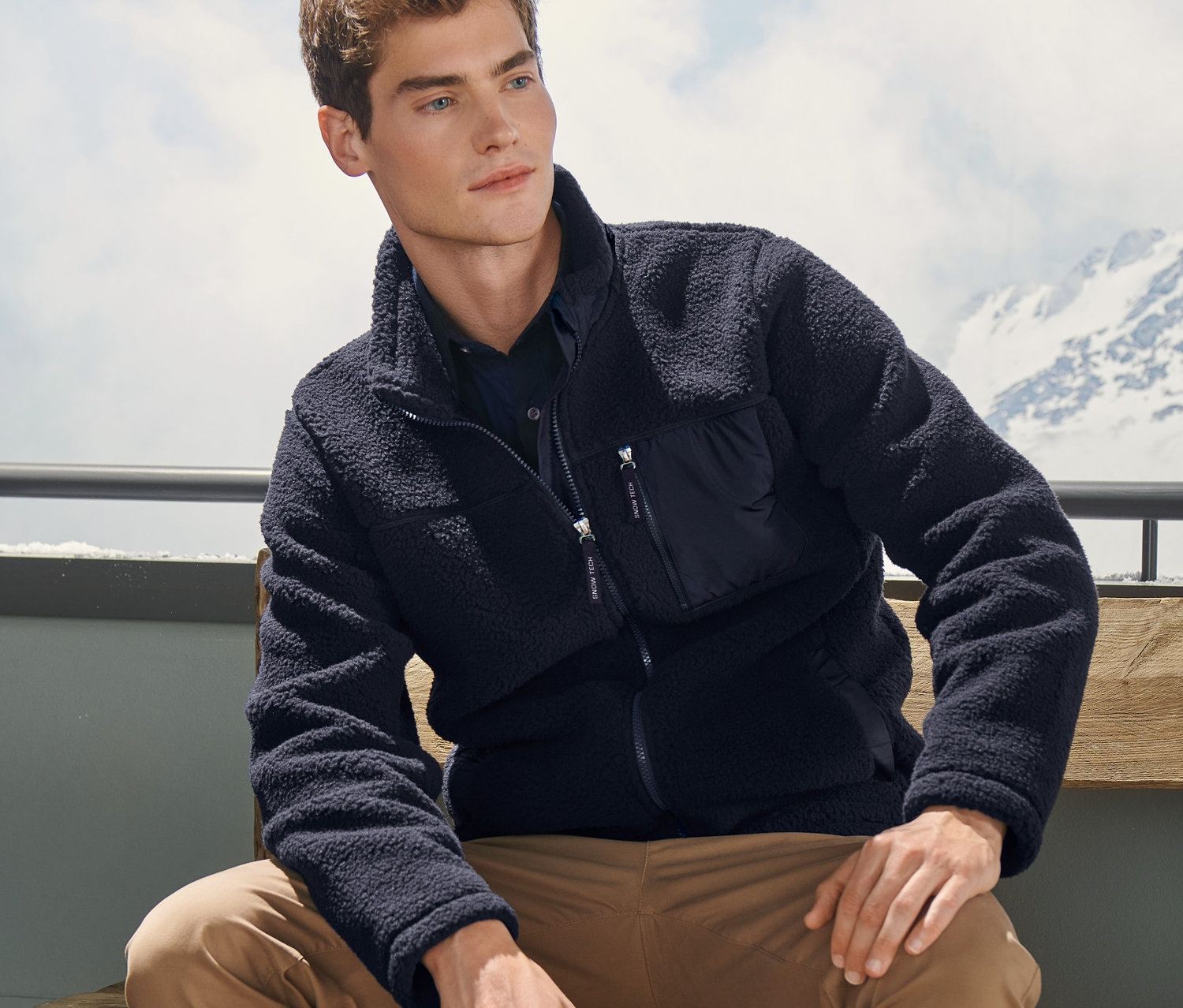 Adam bankta oturuyor, üzerinde Lacivert Pelüş Ceket var.