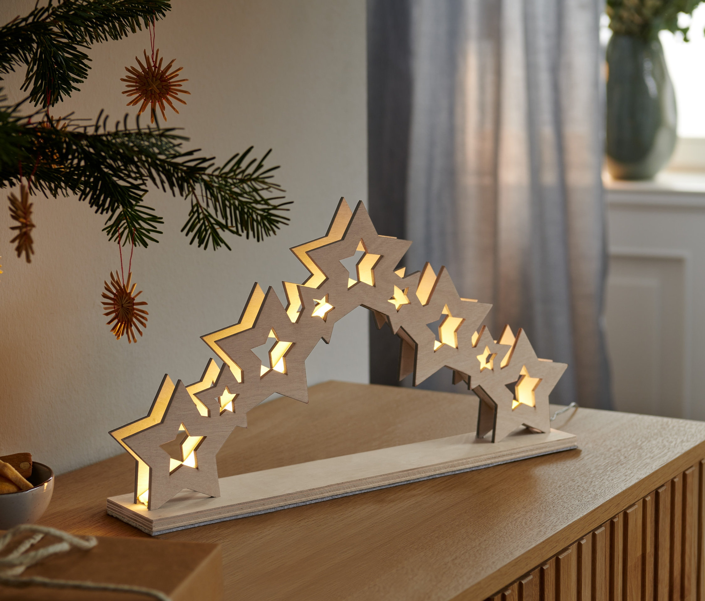 Aydınlatılmış LED yıldız piramidi bir masanın üzerinde duruyor.