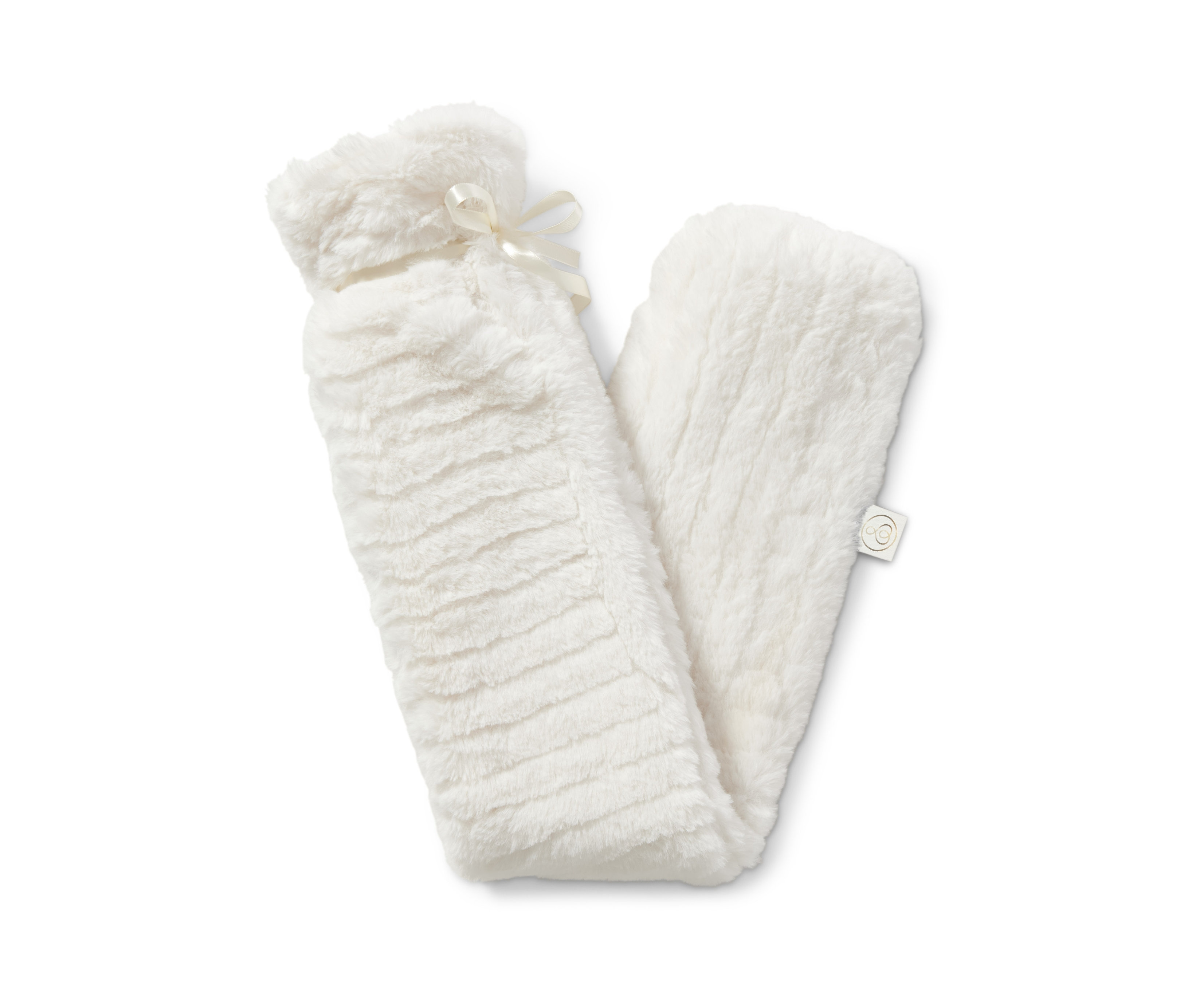 Beyaz pelüş kılıflı ve kurdeleli uzun sıcak su torbası beyaz bir arka plan üzerinde duruyor.