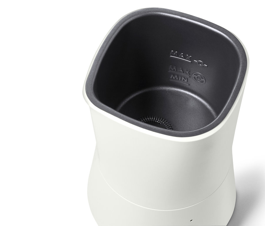 Kremsi beyaz elektrikli süt köpürtücünün yakın çekimi.