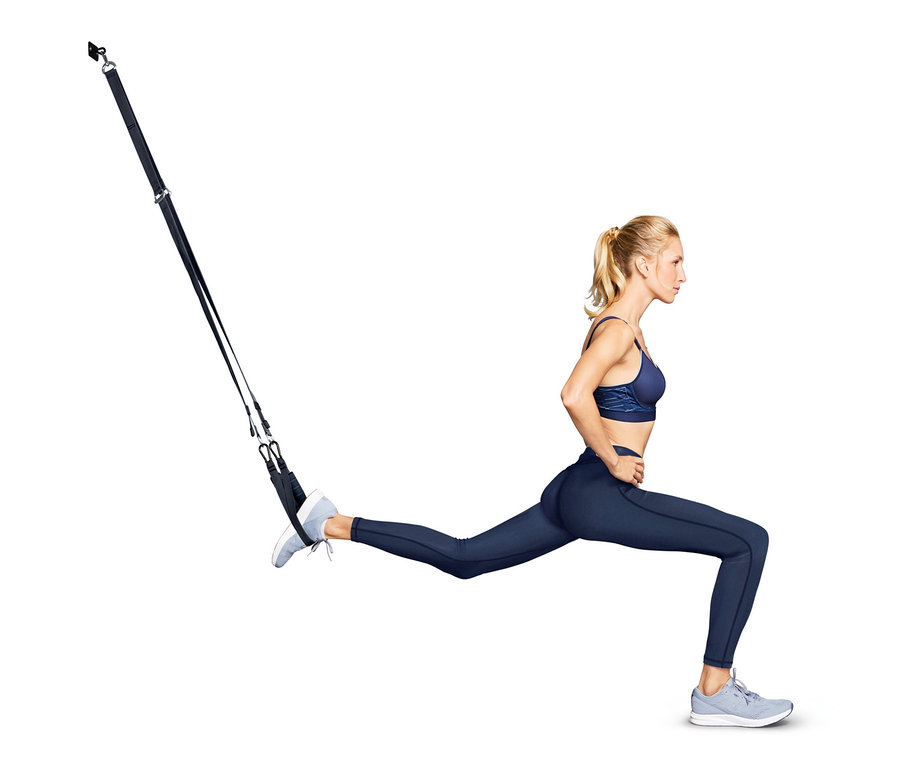 Kadın antrenman kayışı ile hamle yapıyor.