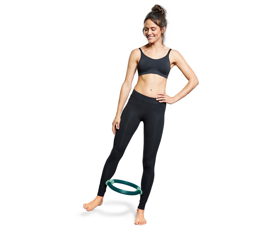 Kadın bacaklarının arasında Pilates çemberi kullanıyor