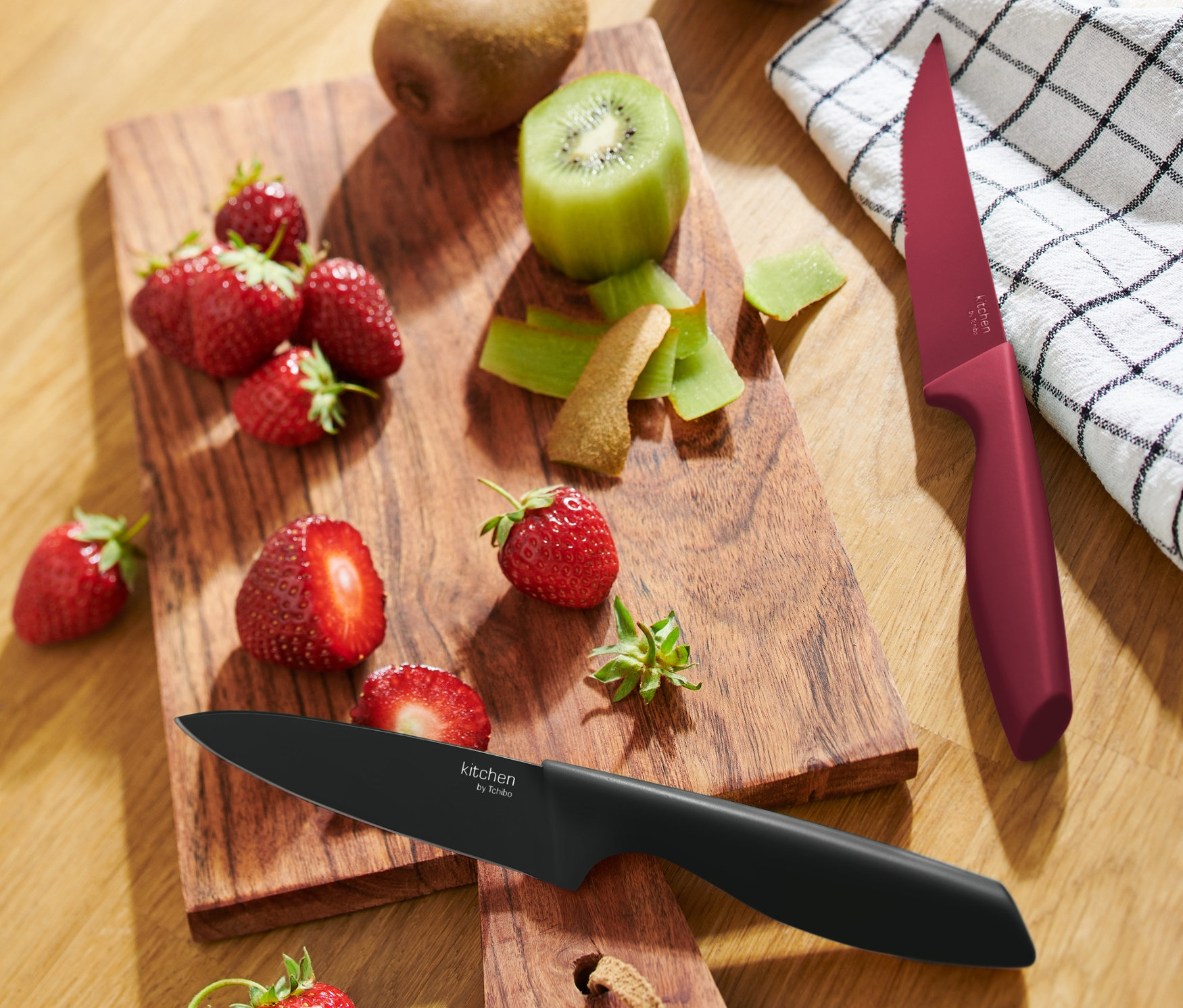 Tahta üzerinde çilek ve kivi ve 2 adet mutfak bıçağı.