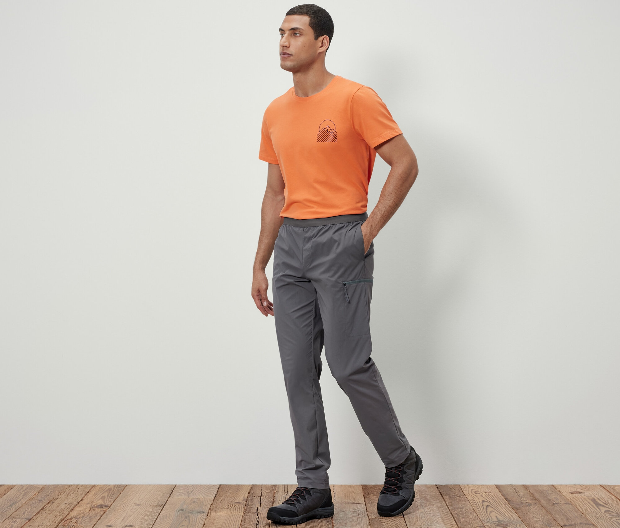 Adam yürüyor ve Hafif Fonksiyonel Pantolon giyiyor.