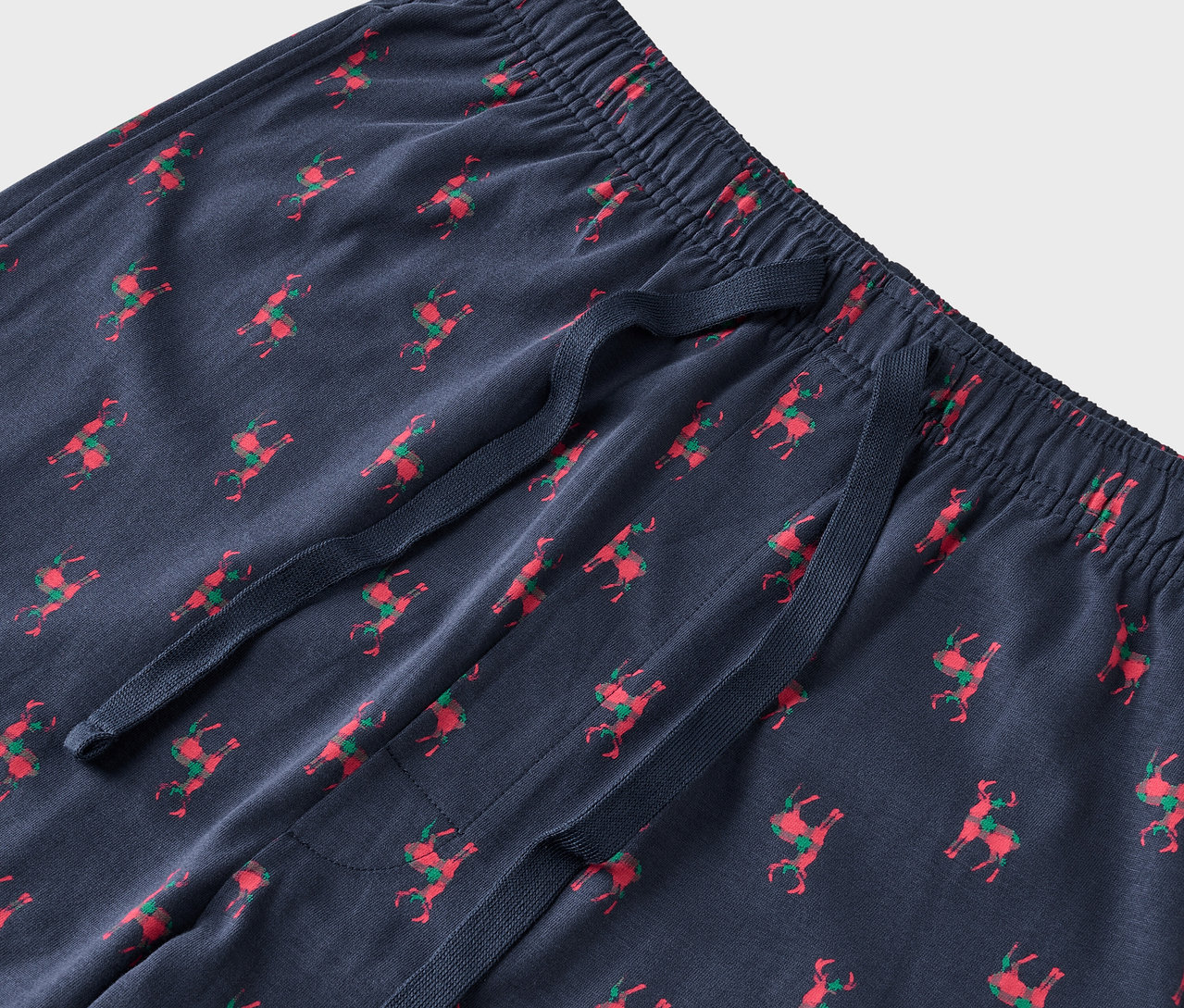 Kırmızı ren geyiği ve yeşil eyerli mavi bir pijama altı detayı.