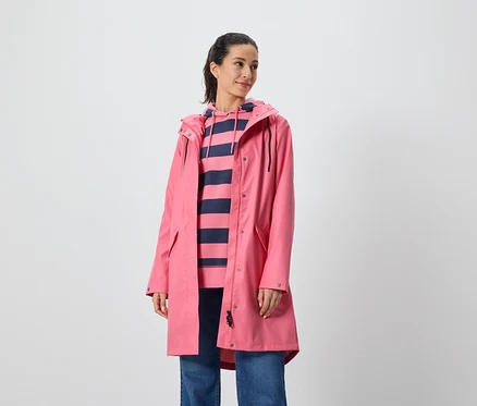 Kadın pembe bir palto ve çizgili kapüşonlu bir sweatshirt giyiyor.