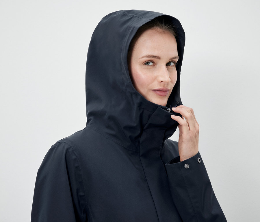 Kadın lacivert kapüşonlu ceket giyiyor.