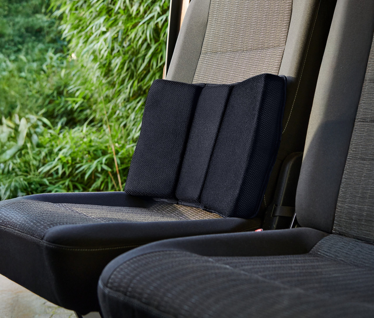 Siyah bir bel yastığı bir araba koltuğunda duruyor.