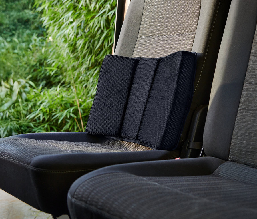 Siyah bir bel yastığı bir araba koltuğunda duruyor.