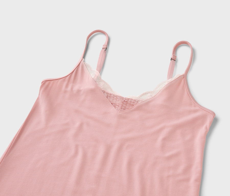 Beyaz bir arka plan üzerinde dantelli pembe bir gecelik.