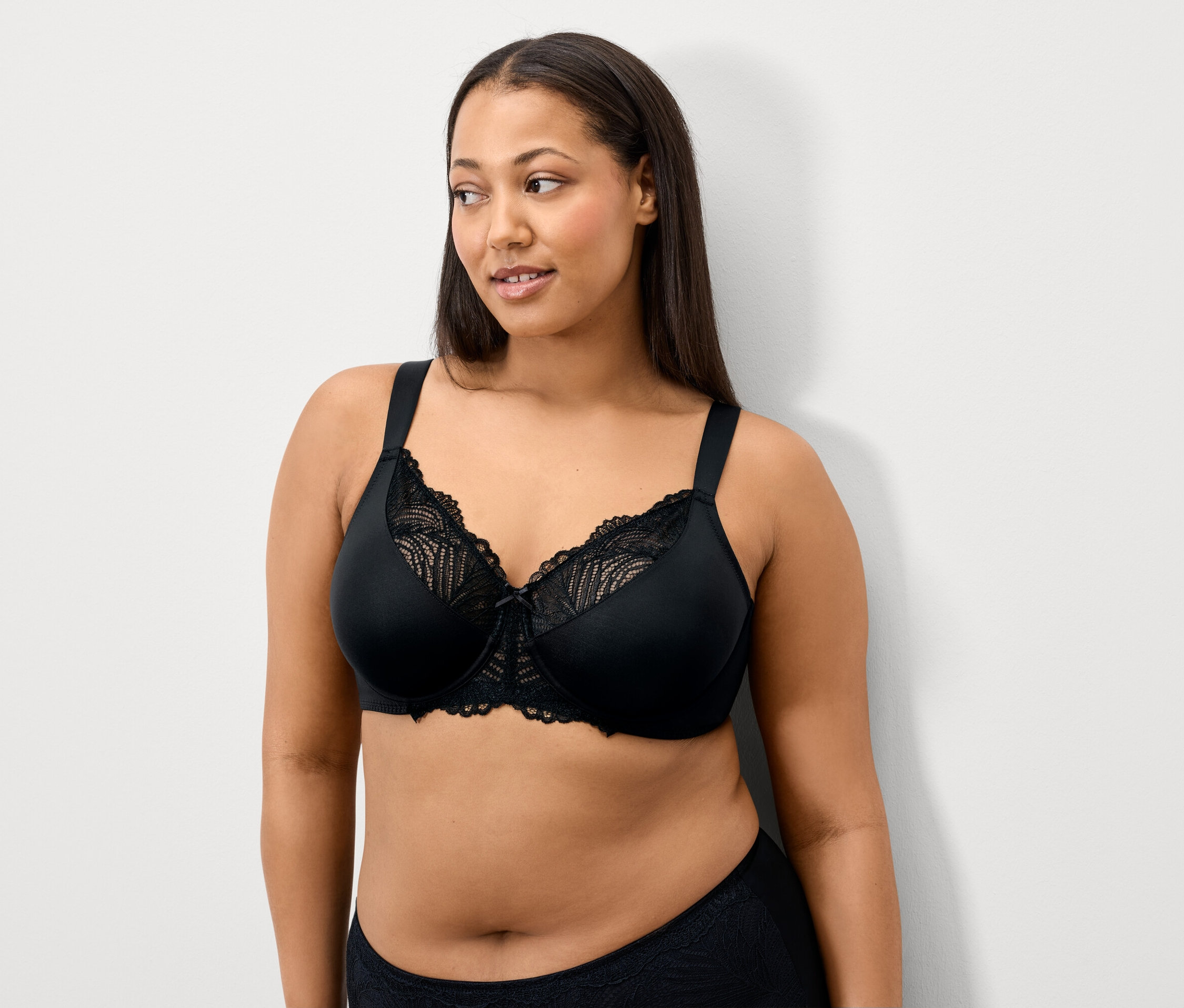 Kadın siyah dantel bir sütyen giyiyor.