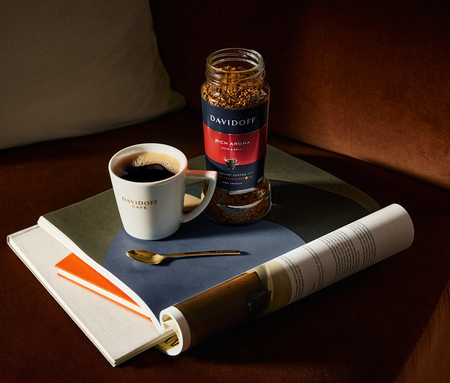 Bir masanın üzerinde Davidoff Café Rich Aroma çözünebilir kahvenin yanında bir fincan kahve.